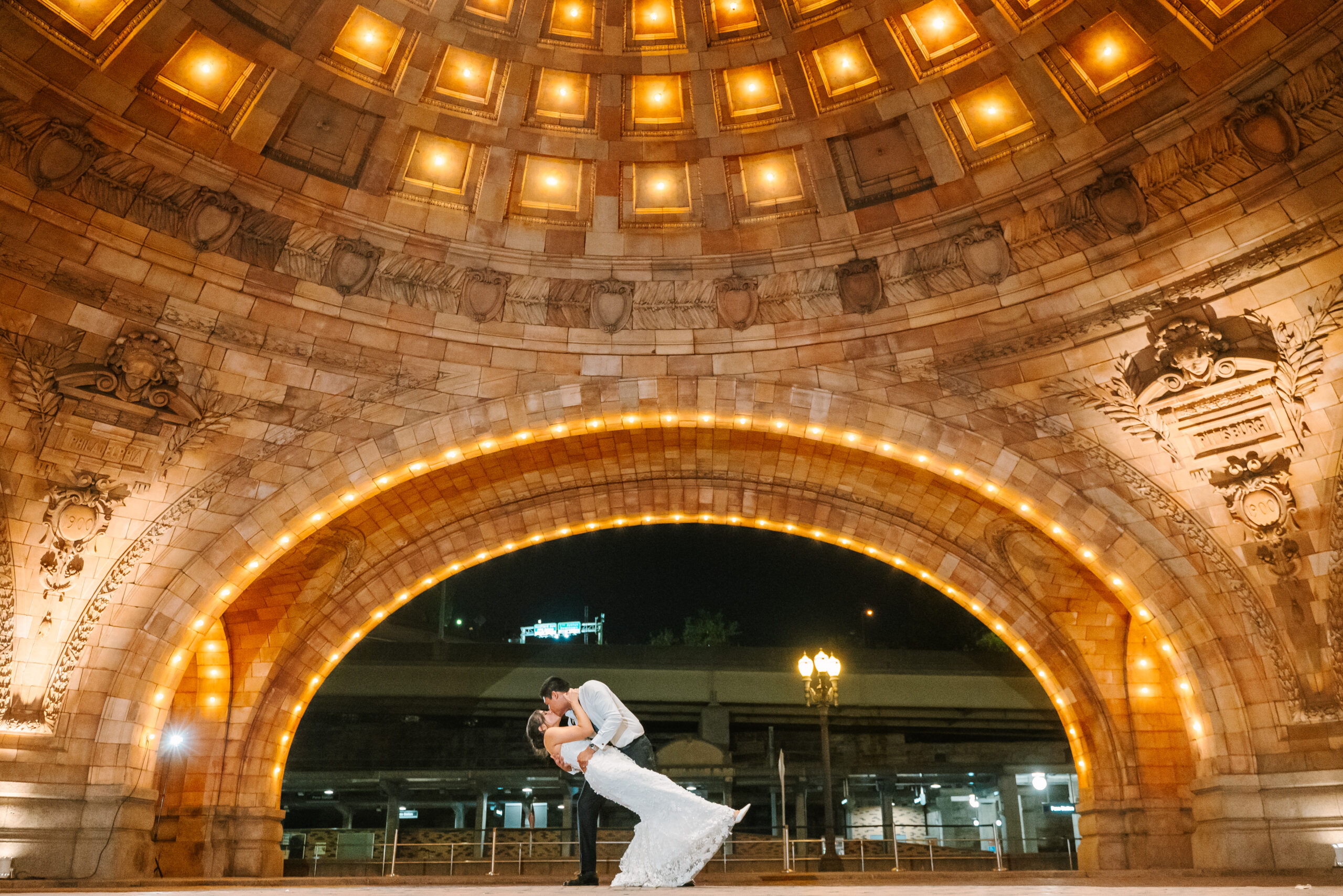 Bride and groom share intimate moment in The Pennsylvanian's grand Rotunda, highlighting the ornate ceiling details above