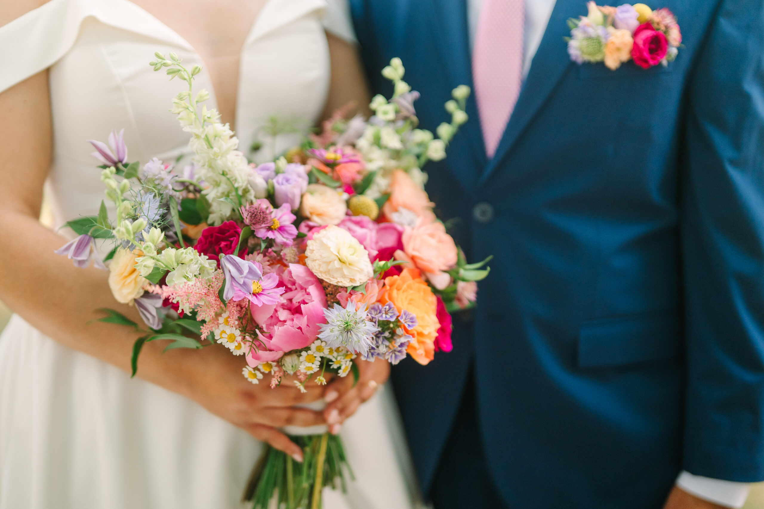 A couple stands with the image focused on their lush florals