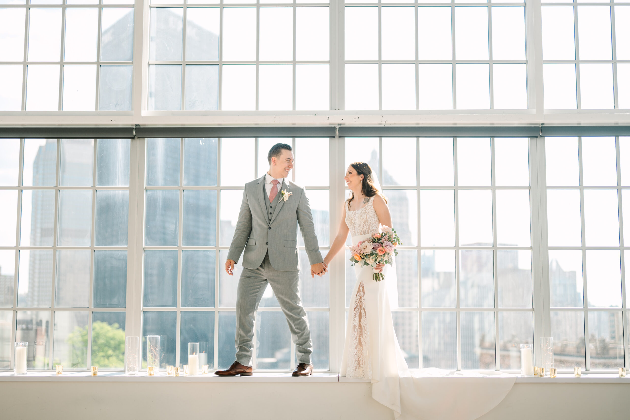 Newlyweds pose for photos in front of the windows of the Brightspace at the Energy and Innovation Center