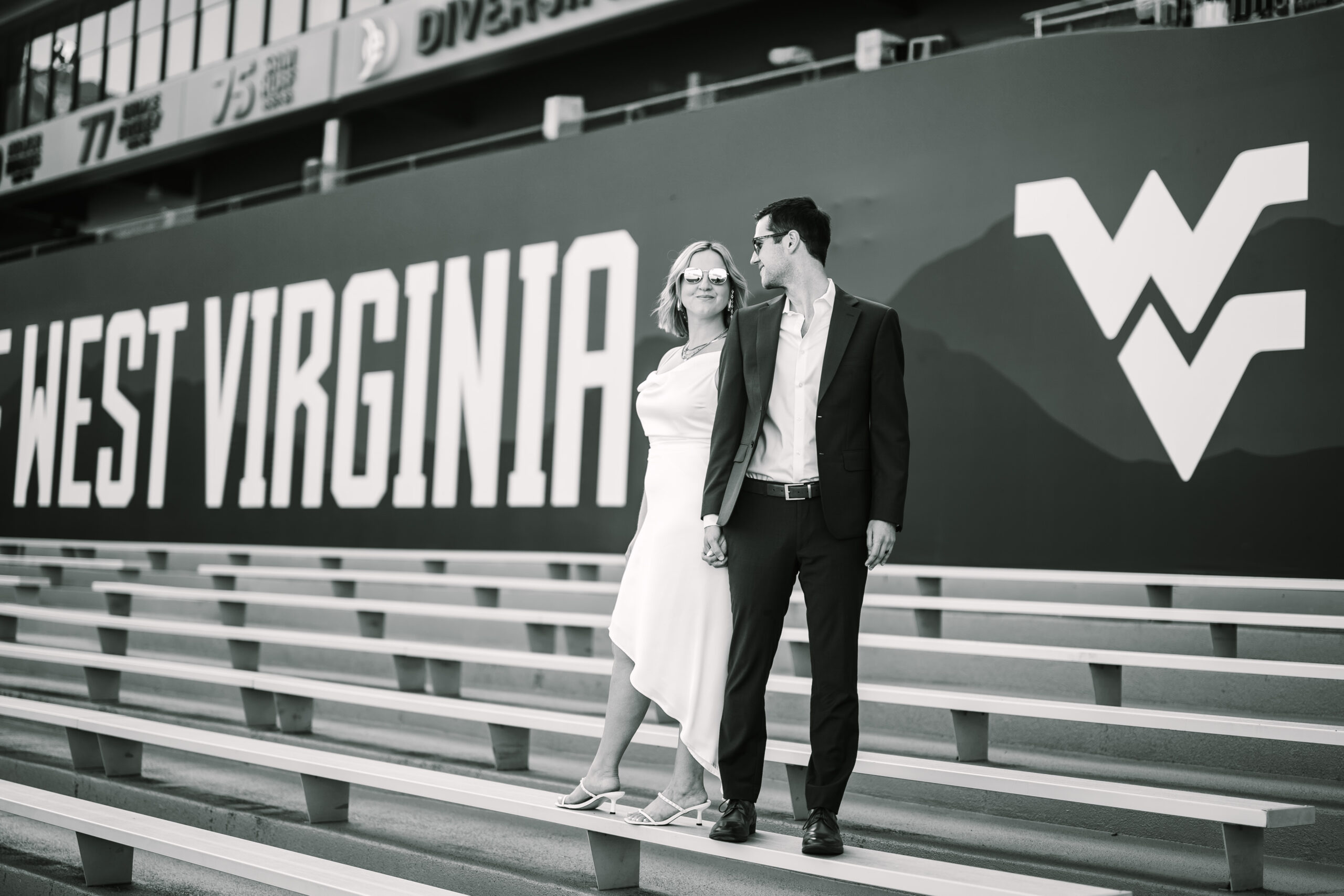 A couple in their reception outfits taking newlywed portraits during their reception at Mountaineer Field