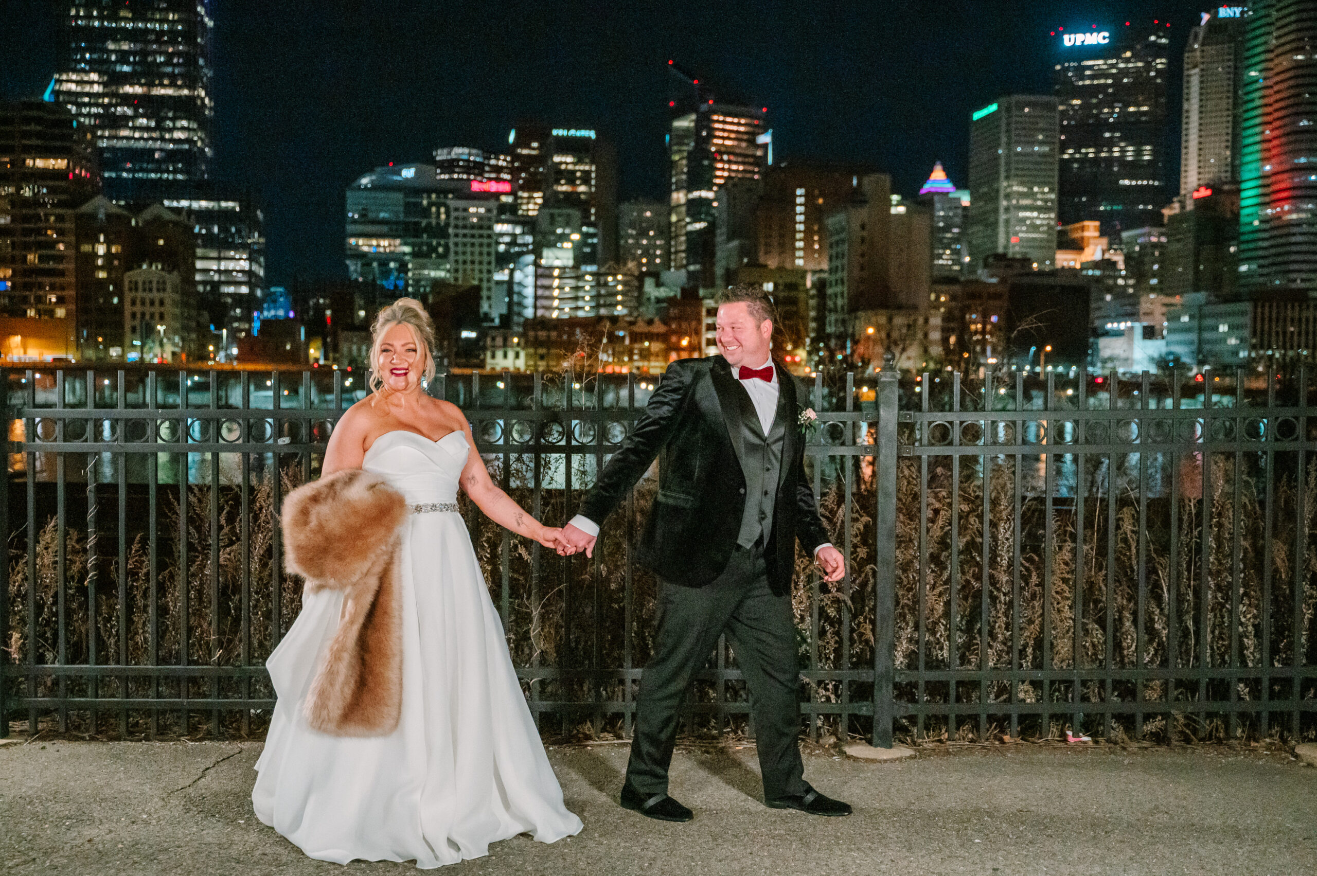 A couple walks along the river outside the Sheraton Station Square